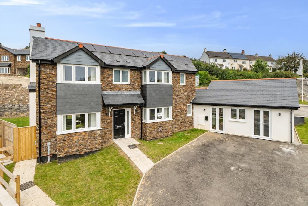 Large detached house with stone cladding and a single storey extension